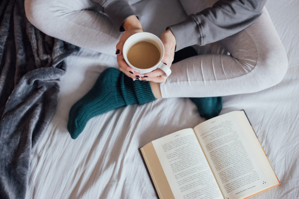 Girl drinking hot tea in bed